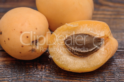 half of apricot on dark wooden table
