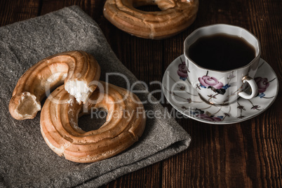 Round eclairs with cup of coffee