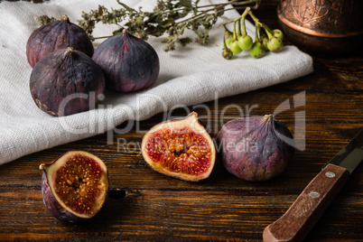 Ripe figs on cloth with sliced one and some objects