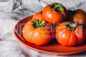 Persimmons on Orange Plate