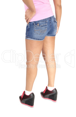 The back of a woman with hands in jeans shorts