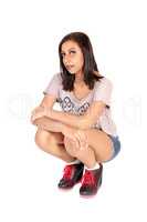 Pretty woman crouching on the floor in shorts