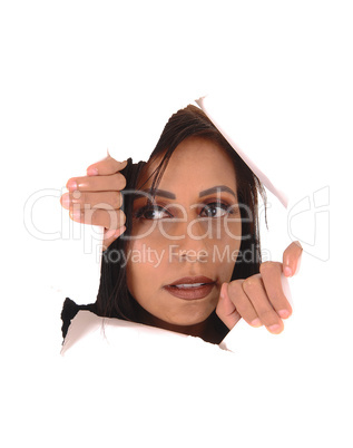 Woman looking through a hole in a paper