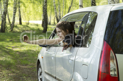 Young woman and dog taking selfie in car