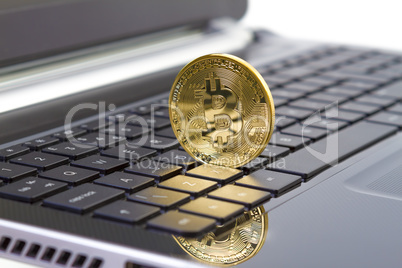 Golden bitcoin digital currency on laptop keyboard