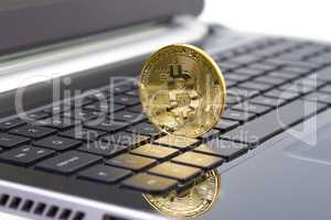 Golden bitcoin digital currency on laptop keyboard