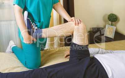 Physiotherapist doing exercises for leg recovery to immobilized