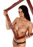Nude woman holding up picture frame