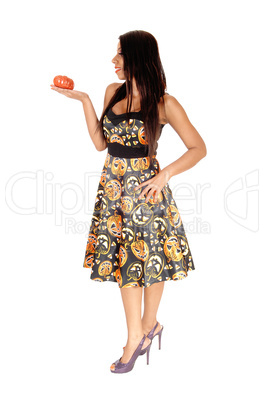 Tall woman standing in halloween dress with pumpkin