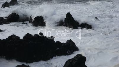 Waves crashing on jagged rocks.