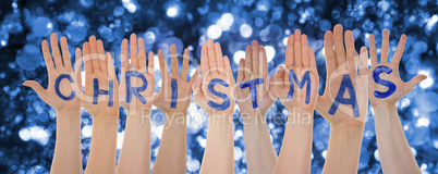 Hands Building Word Christmas, Glittering And Sparkling Bokeh Background