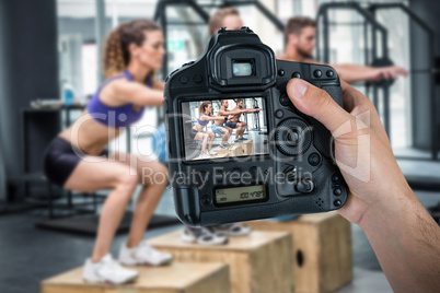 Composite image of cropped hand of photographer holding camera