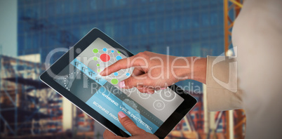 Composite 3d image of businesswoman using digital tablet