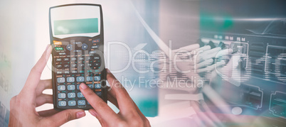 Composite image of cropped hands of businesswoman using calculator