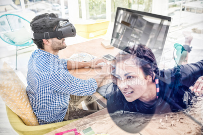Composite image of graphic designer in virtual reality simulator while using computer