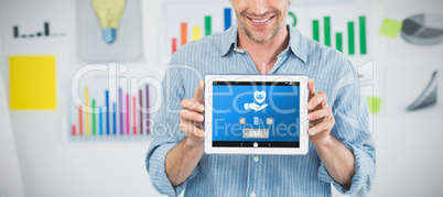 Composite image of businessman showing digital tablet with blank screen in creative office