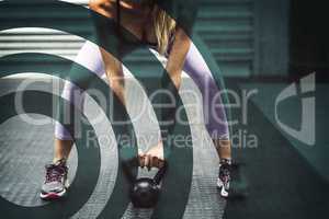 Muscular woman lifting kettlebells