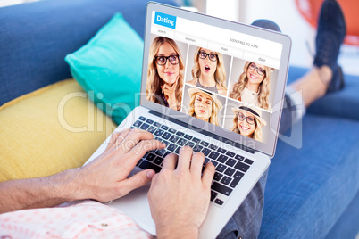 Composite image of low section of male executive using laptop while sitting on sofa