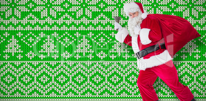 Composite image of santa walking with his sack and bell