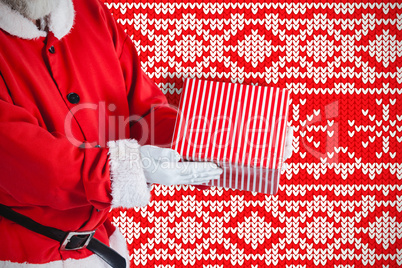Composite image of santa claus holding a gift box