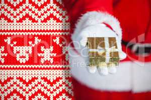 Composite image of santa claus holding a gift box in hand