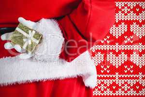 Composite image of santa claus holding gift box behind his back