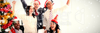 Composite image of nice business team punching the air to celebrate christmas