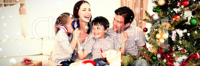 Composite image of happy family playing with christmas gifts