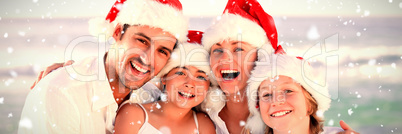 Composite image of family during christmas day at the beach