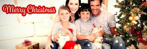 Composite image of happy family at christmas time holding lots of presents