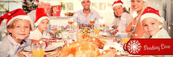 Composite image of happy family wearing santa hats around the dinner table