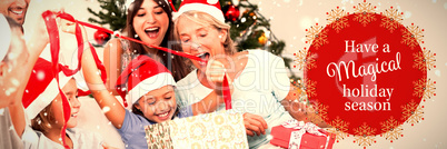 Composite image of happy family at christmas opening gifts together