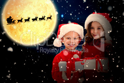 Composite image of cute siblings with gifts