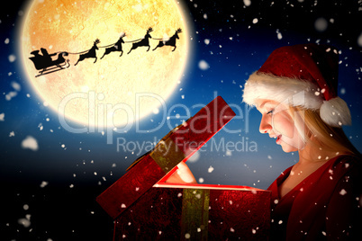 Composite image of festive blonde opening a gift