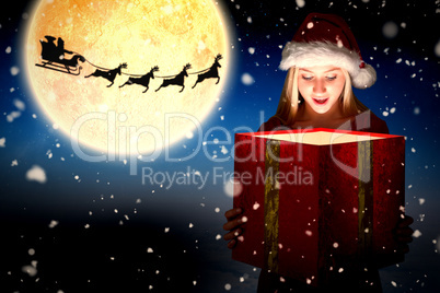 Composite image of festive blonde holding a gift