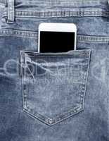 white smartphone in the back pocket of blue jeans