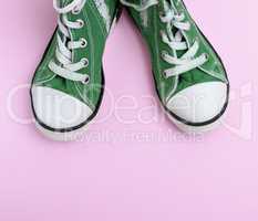 pair of green children's shoes on a pink background