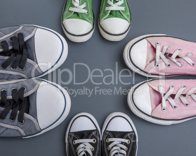 four pairs of old textile sneakers on a black background