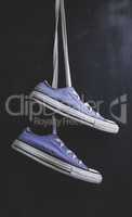 pair of purple textile sneakers hanging on a lace