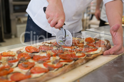 Pizza maker cutting romana focaccia