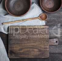 empty old cutting board, spoon and two empty clay bowls