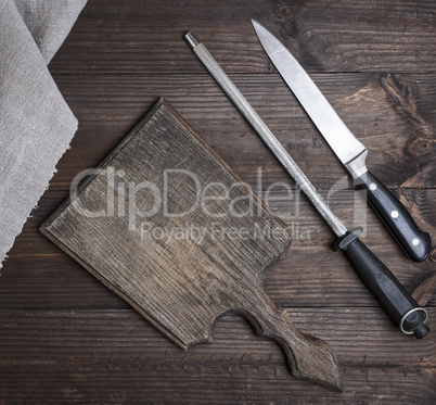 knife sharpener, knife and old empty wooden cutting board