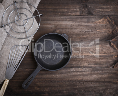 empty black round cast iron pan, spatula and stand