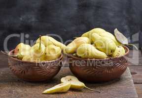 ripe fresh yellow pears in a clay bowl