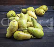 ripe green pears on a brown wooden background