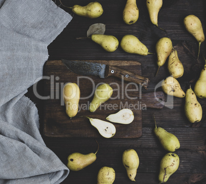ripe green pears scattered on a brown wooden table