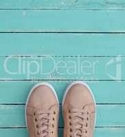 pink pair of female leather sneakers with laces