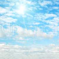 Sun on blue sky with white clouds.