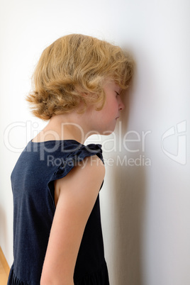 Child is standing with face to the wall