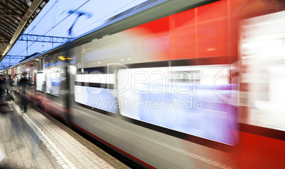 Motion blurred speed moving railroad train at railway station platform